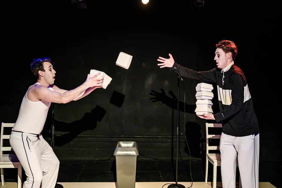 Nick Hyde and Oliver Maynard throw takeaway boxes between one another in Double Act