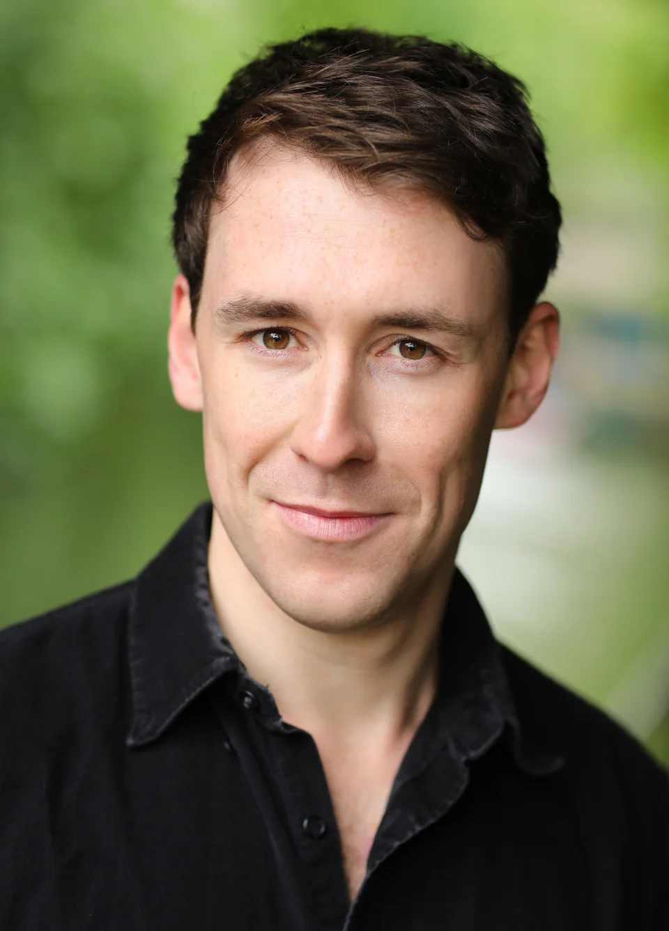 Nick Hyde clean-shaven, in a black shirt